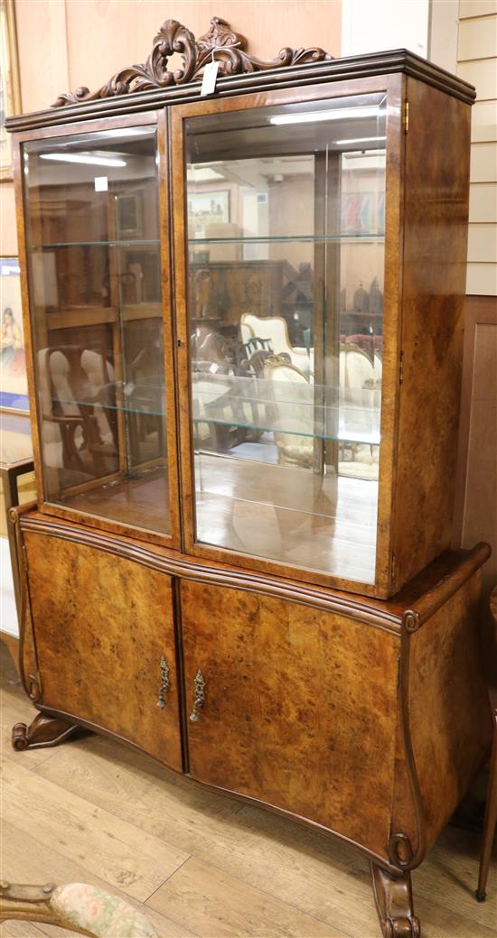 A 1930s walnut china display cabinet on cupboard base W.140cm